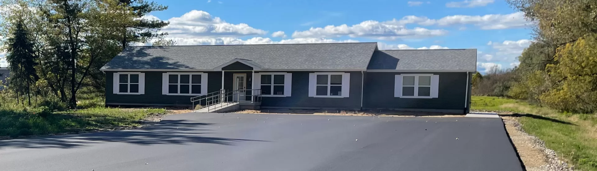 Courter Memory Center in Comstock Township with wheelchair ramp access, surrounded by green forest area, offering memory care services for alzheimer's and dementia patients